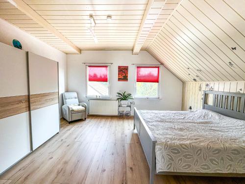 a large bedroom with a bed and a chair at Im Herzen von Wermelskirchen in Wermelskirchen