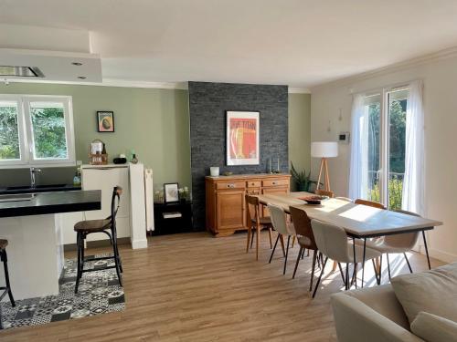 a kitchen and living room with a table and chairs at Maison de famille 5 ch idéale pour des réunions de familles in Sainte-Luce-sur-Loire