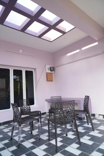 a room with chairs and a table and a ceiling at Hill View Paradise - A luxurious 2bhk's & Private Rooms Near Bhudevi Complex TTD Ticket Counter Alipiri in Tirupati
