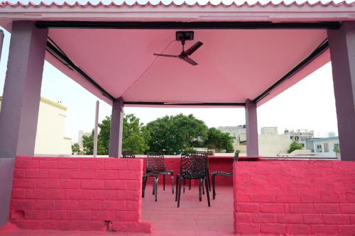a group of chairs and tables under a pink pavilion at Hill View Paradise - A luxurious 2bhk's & Private Rooms Near Bhudevi Complex TTD Ticket Counter Alipiri in Tirupati