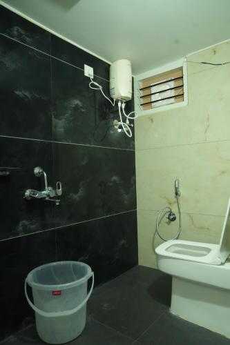 a bathroom with a toilet and a sink and a bucket at Hill View Paradise - A luxurious 2bhk's & Private Rooms Near Bhudevi Complex TTD Ticket Counter Alipiri in Tirupati