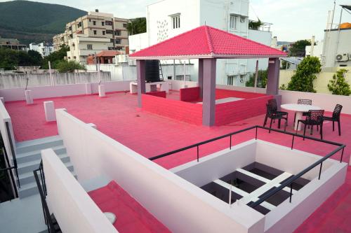a balcony with a red roof with a table and chairs at Hill View Paradise - A luxurious 2bhk's & Private Rooms Near Bhudevi Complex TTD Ticket Counter Alipiri in Tirupati