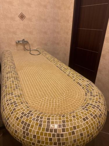 a bathroom with a tiled toilet in a room at Alpine Lodge Bansko Apartments in Bansko