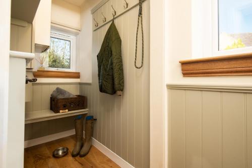 a hallway with boots on the floor and a window at Orchard Cottage in Cornhill-on-tweed