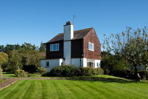 a house with a chimney on top of a yard at Orchard Cottage in Cornhill-on-tweed