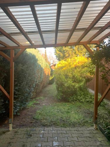 a wooden pergola over a walkway in a garden at Gepflegtes-Ferienhaus-am-Dankernsee-Haren-Emsland in Haren