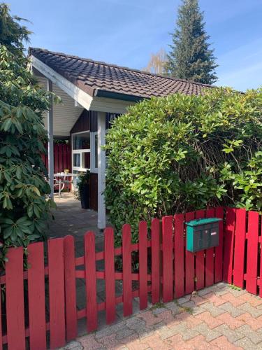 a red fence in front of a house at Gepflegtes-Ferienhaus-am-Dankernsee-Haren-Emsland in Haren