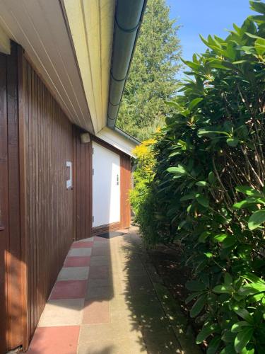 a hallway of a building next to a hedge at Gepflegtes-Ferienhaus-am-Dankernsee-Haren-Emsland in Haren