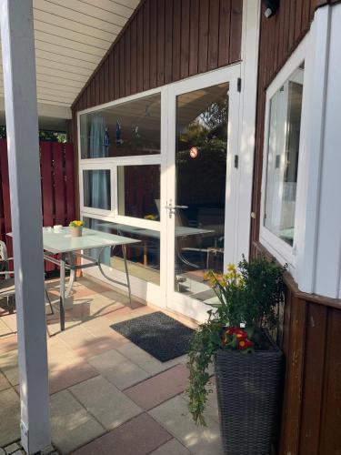 an outdoor patio with a table and a glass door at Gepflegtes-Ferienhaus-am-Dankernsee-Haren-Emsland in Haren