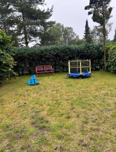 two childrens play equipment in the grass in a yard at Gepflegtes-Ferienhaus-am-Dankernsee-Haren-Emsland in Haren