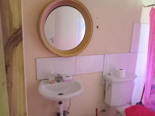 a bathroom with a sink and a mirror and a toilet at Lovely 1-Bed Cottage in St catherine Jamaica in Ewarton