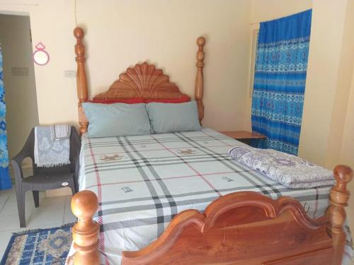 a bedroom with a wooden bed with a wooden frame at Lovely 1-Bed Cottage in St catherine Jamaica in Ewarton