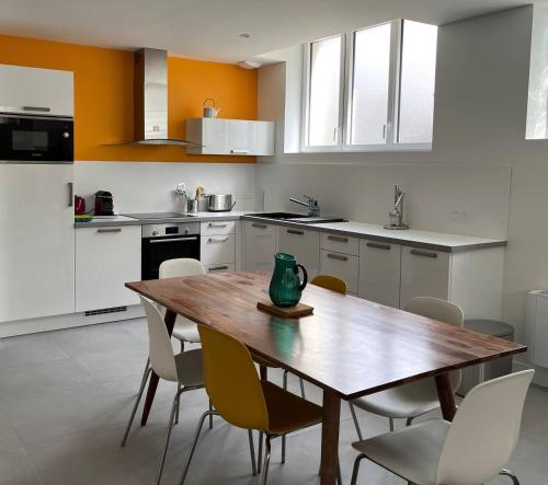 une cuisine avec une table et des chaises en bois dans l'établissement La Foliotte - Appartement Jacuzzi, à Jullouville