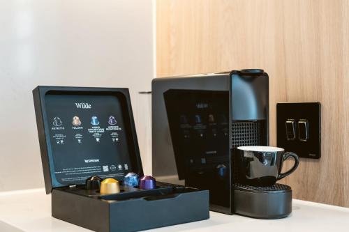 a computer monitor and a coffee mug on a counter at Wilde Aparthotels Manchester City Centre in Manchester