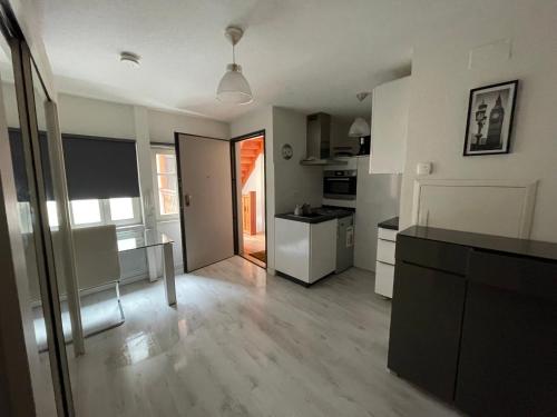 Il comprend une grande cuisine avec des murs blancs et du parquet. dans l'établissement Magnifique studio proche Cathédrale, à Strasbourg