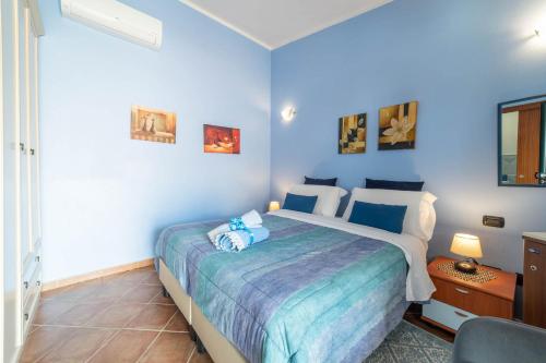 a bedroom with a large bed with blue walls at B&B Rita E Renzo in Riola Sardo