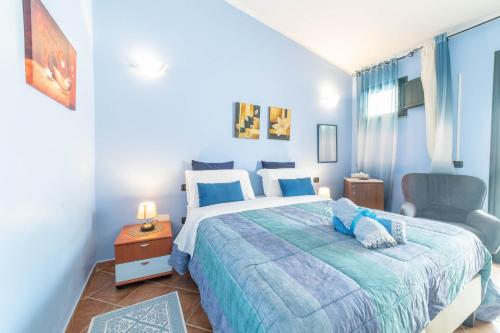 a blue bedroom with a bed and a chair at B&B Rita E Renzo in Riola Sardo