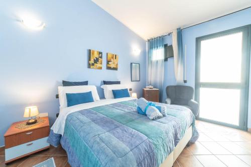 a blue bedroom with a bed and a chair at B&B Rita E Renzo in Riola Sardo