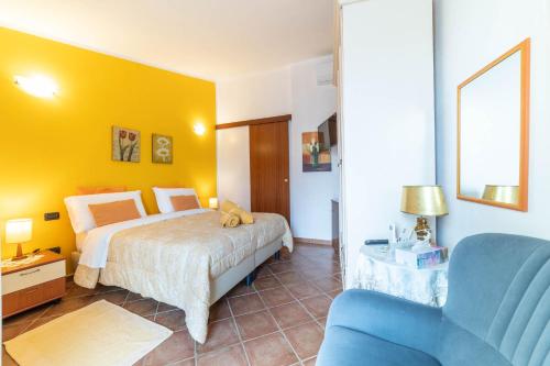 a bedroom with a bed and a blue chair at B&B Rita E Renzo in Riola Sardo