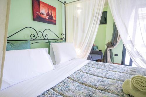a bedroom with a large bed with white pillows at B&B Rita E Renzo in Riola Sardo