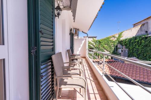 a balcony with chairs on a house at B&B Rita E Renzo in Riola Sardo