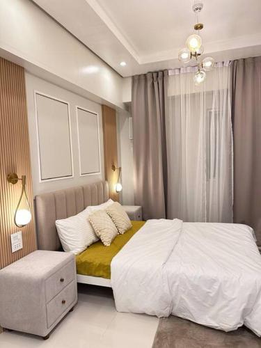 a bedroom with a white bed and a window at Haiya's Staycation Aesthetic & Cozy in Tagaytay in Biluso