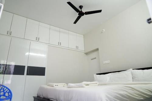 a bedroom with a large bed with a ceiling fan at Hill View Paradise - A luxurious 2bhk's & Private Rooms Near Bhudevi Complex TTD Ticket Counter Alipiri in Tirupati