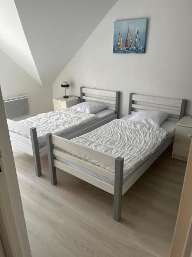 une chambre avec deux lits et un tableau au mur dans l'établissement Angenehmes Haus, à Perros-Guirec