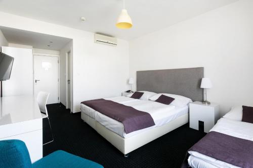 a hotel room with two beds and a television at My Hotel Apollon in Prague