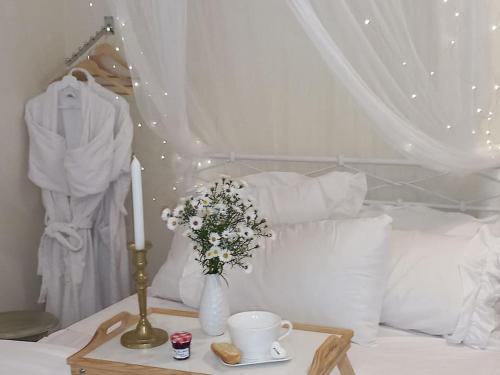 - un lit avec une bougie et un vase de fleurs sur une table dans l'établissement Le studio Une bulle de douceur, à Beaune