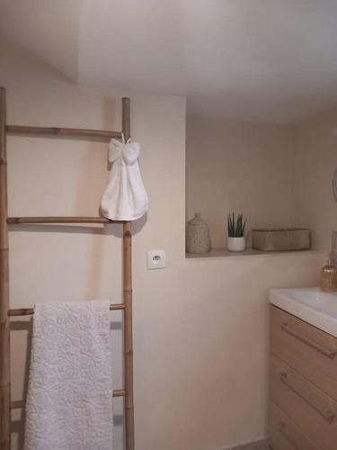 La salle de bains est pourvue d'un lavabo blanc et d'une serviette. dans l'établissement Le studio Une bulle de douceur, à Beaune