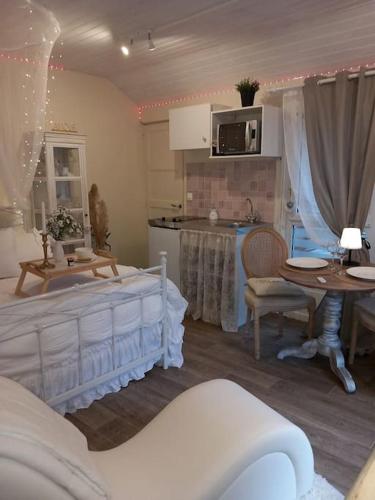 - une cuisine avec un lit et une table dans une chambre dans l'établissement Le studio Une bulle de douceur, à Beaune