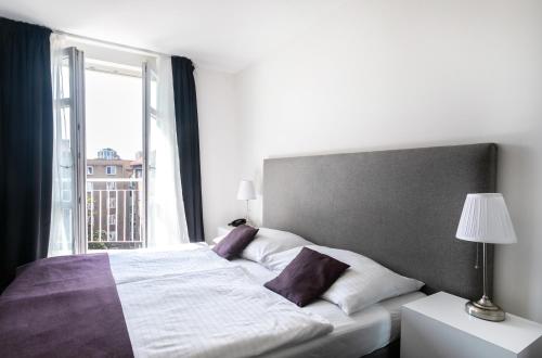 a bedroom with a large bed and a window at My Hotel Apollon in Prague