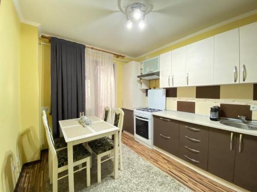 a small kitchen with a table and a table and chairs at Комната in Chişinău