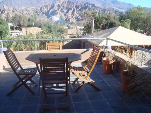 a table and chairs on a balcony with mountains at Las Marías Hotel Boutique in Tilcara