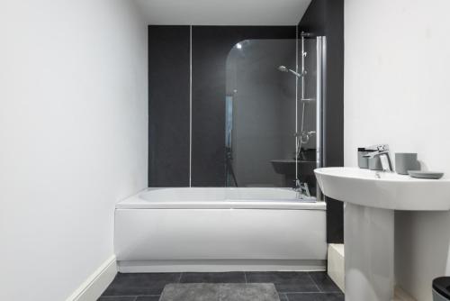 a bathroom with a white tub and a sink at The Old Embassy by Guestz in Hull