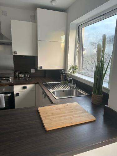 a kitchen with a wooden cutting board on the counter at Black Daisy in Glasgow