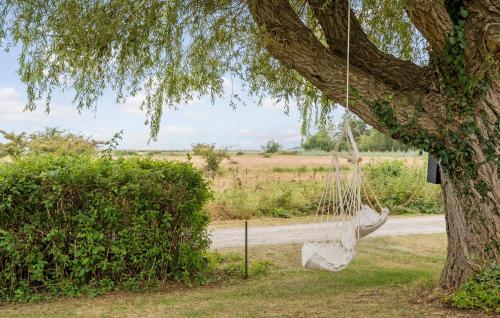 a white hammock hanging from a tree at 2 Bedroom Beach Front Home In Rude in Rude