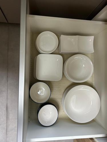 a group of white plates and bowls in a refrigerator at JaM in Noboribetsu