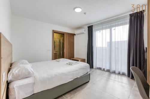 a bedroom with a large bed and a large window at The St Pauls Bay Escape Suites by 360 Estates in St Paul's Bay
