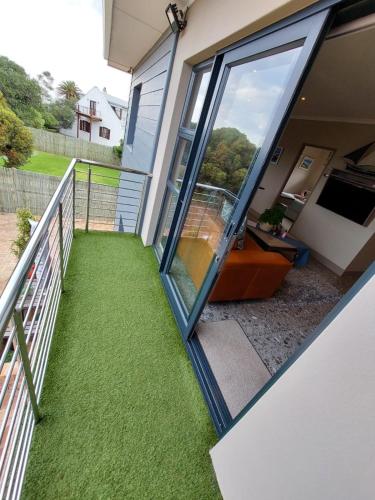 a balcony of a house with green grass at Karibu Self-catering Accommodation in Hermanus