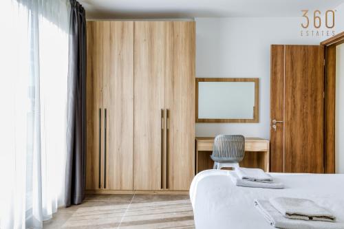 a bedroom with a bed and a desk and a chair at The St Pauls Bay Escape Suites by 360 Estates in St Paul's Bay