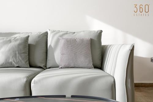 a white couch with a black and white pillow at The St Pauls Bay Escape Suites by 360 Estates in St Paul's Bay