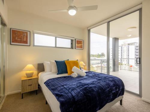 a bedroom with a bed and a large window at Modern 3BR Riverside APT w Parking near Shops and Park in Brisbane