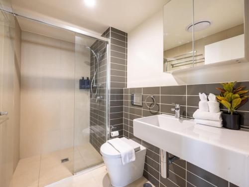a bathroom with a toilet and a sink and a shower at Modern 3BR Riverside APT w Parking near Shops and Park in Brisbane
