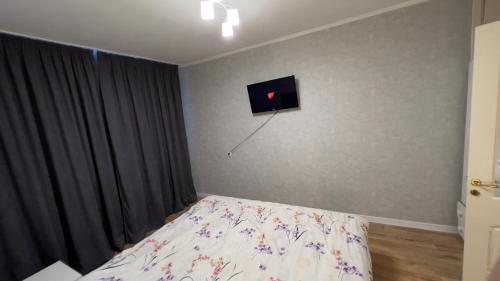 a bedroom with a bed and a tv on the wall at Rent&live part apartment in Codru