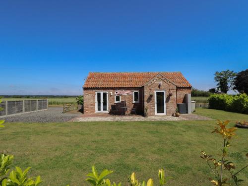 a small brick house in a field of grass at The Stable in Boston