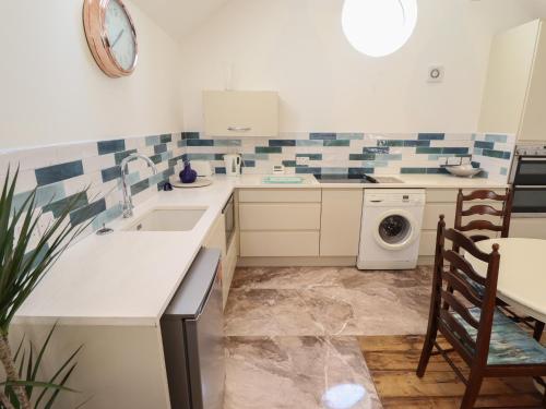 a kitchen with a sink and a washing machine at The Stable in Boston