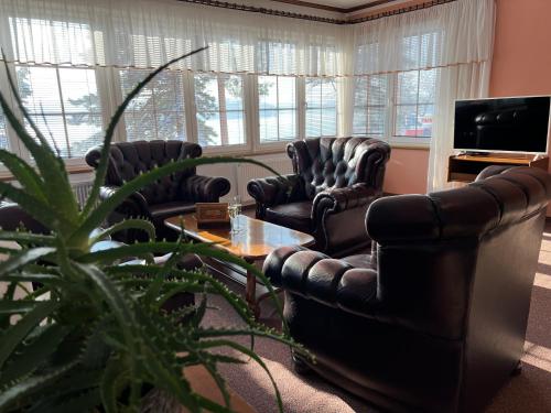 salon z 2 krzesłami, stołem i telewizorem w obiekcie Resort Maják w mieście Horní Soběšovice