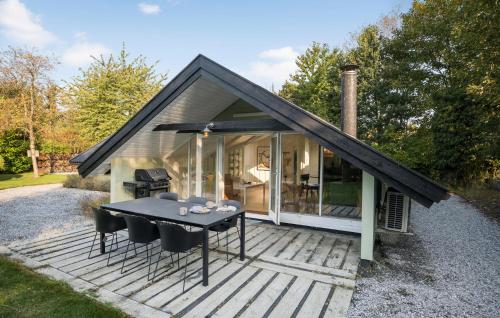 a small house with a table and chairs on a deck at 4 Bedroom Stunning Home In Tisvildeleje in Tisvildeleje